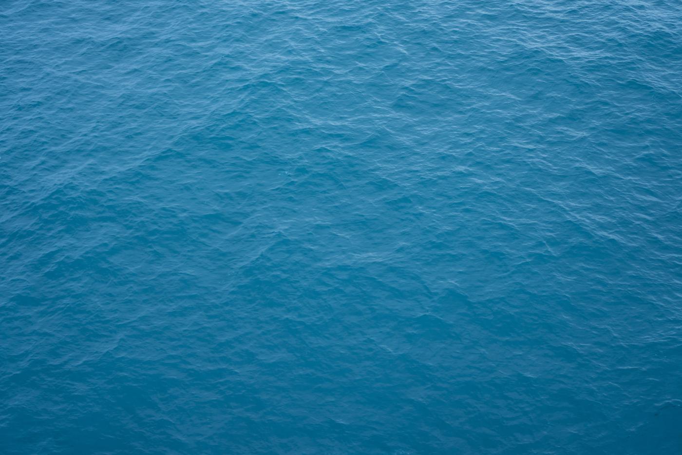 Open sea in soft blue light with no horizon and no land in the frame