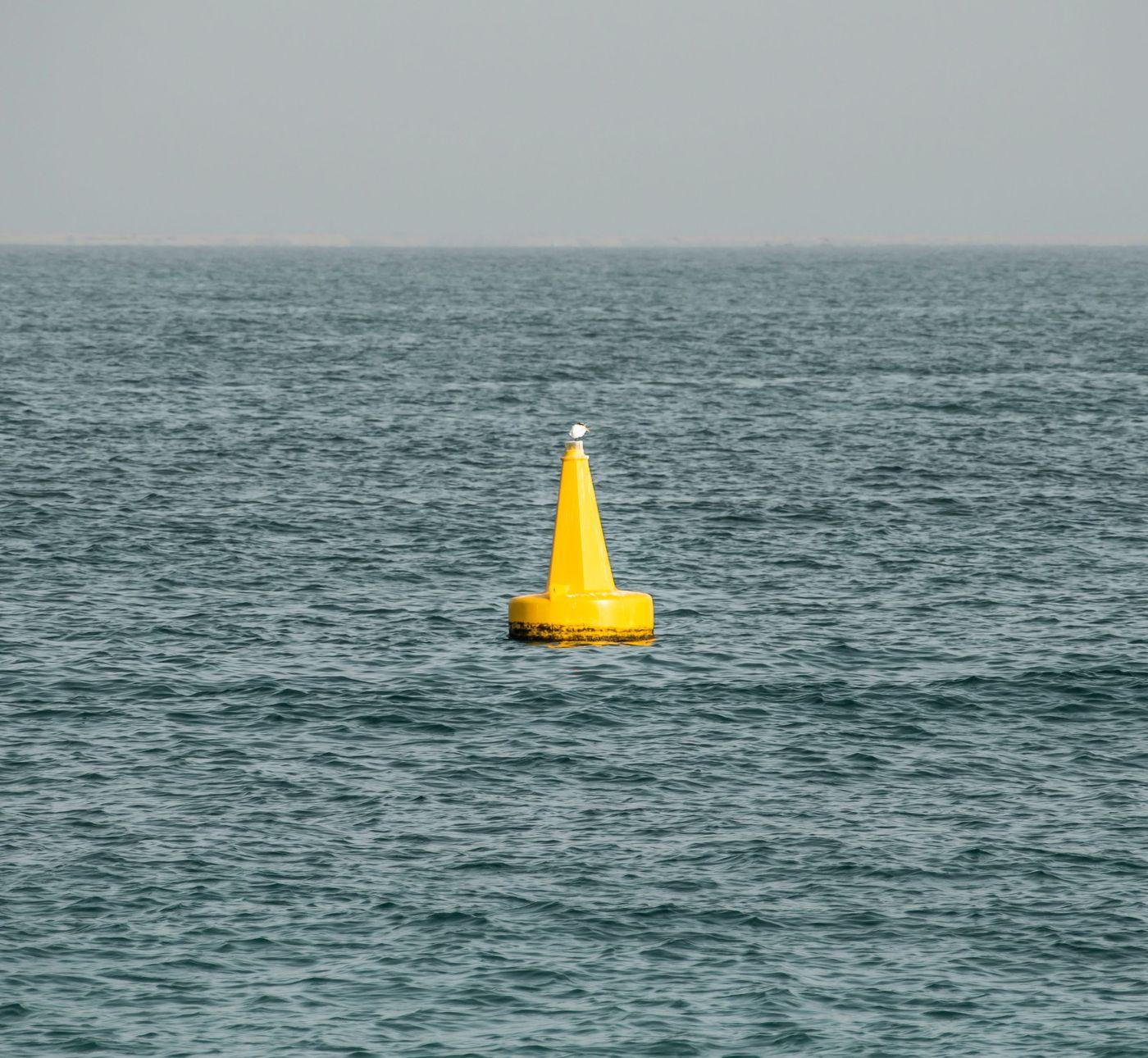 A yellow instrumented buoy floating in open ocean